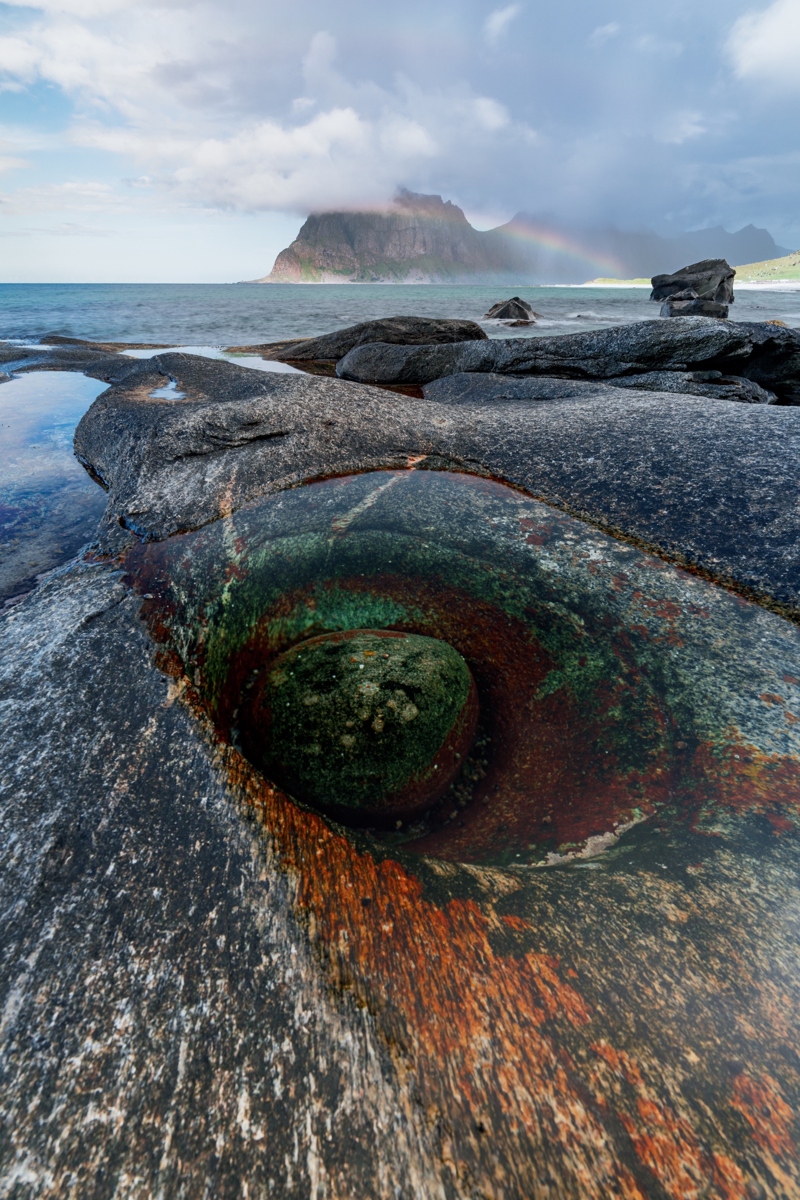 Colourful tidal pool known as the Dragon’s Eye in weathered coastal rock in the Lofoten Islands