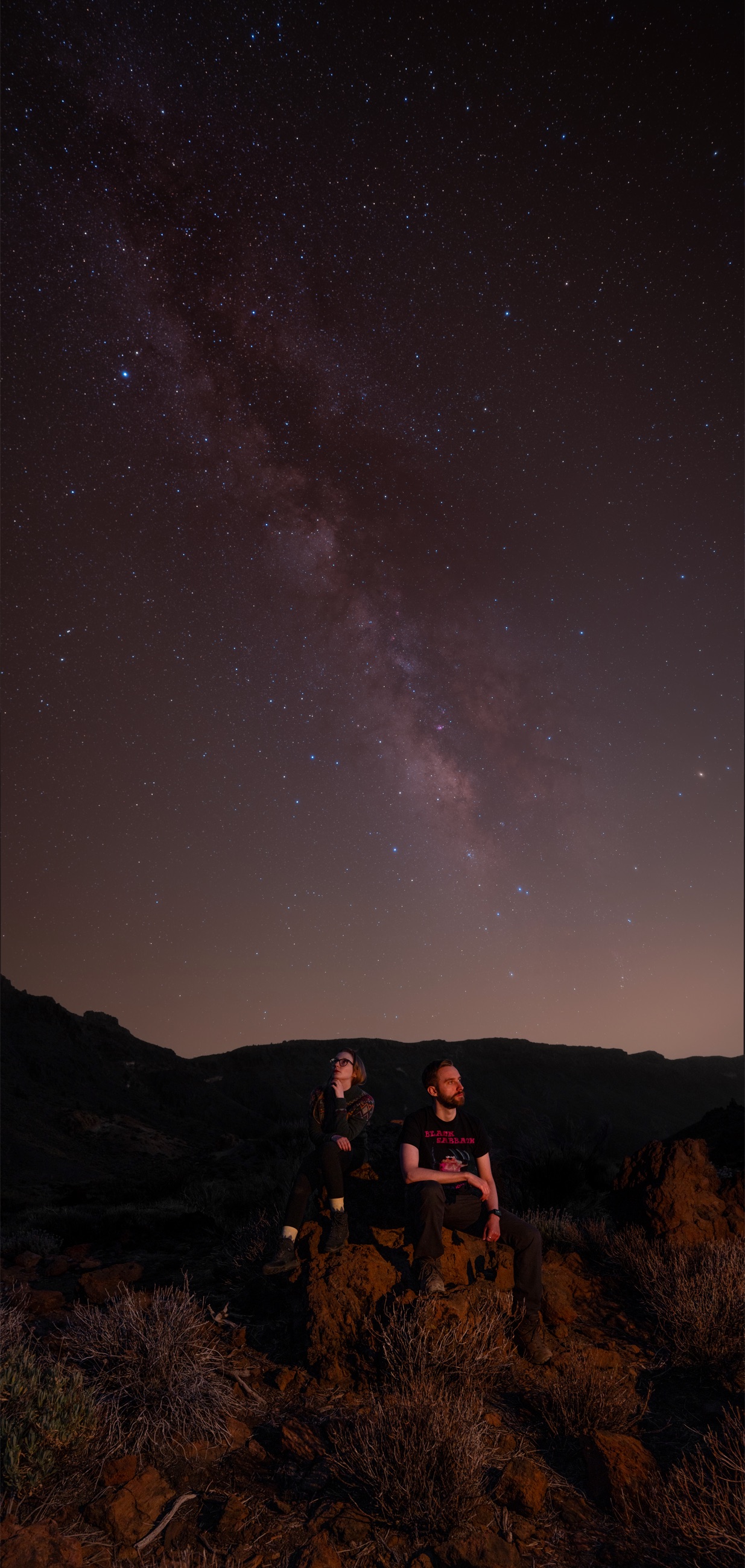Two people standing beneath the Milky Way in Tenerife
